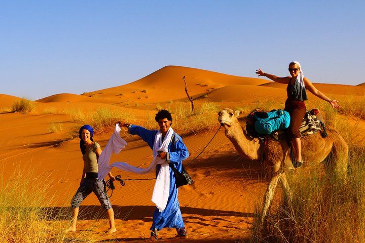 Un nomade guide une famille dans le désert.